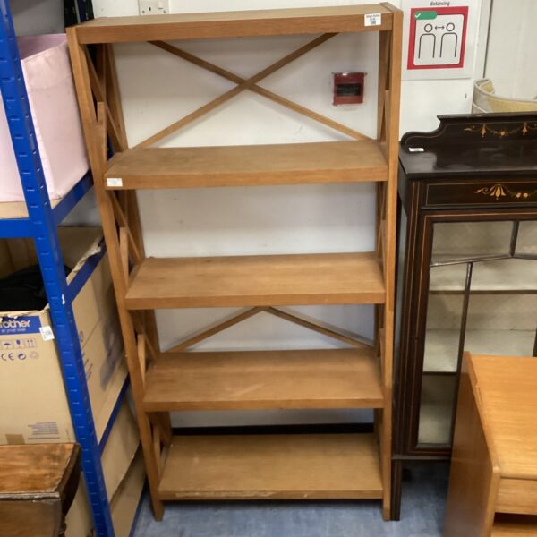 Wooden lattice shelving unit with three tiers for display.