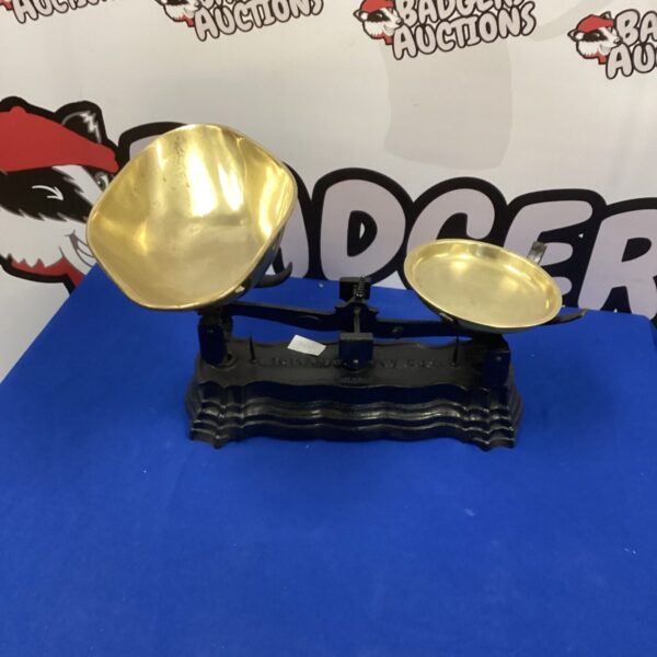 Vintage brass balance scales on a wooden base.