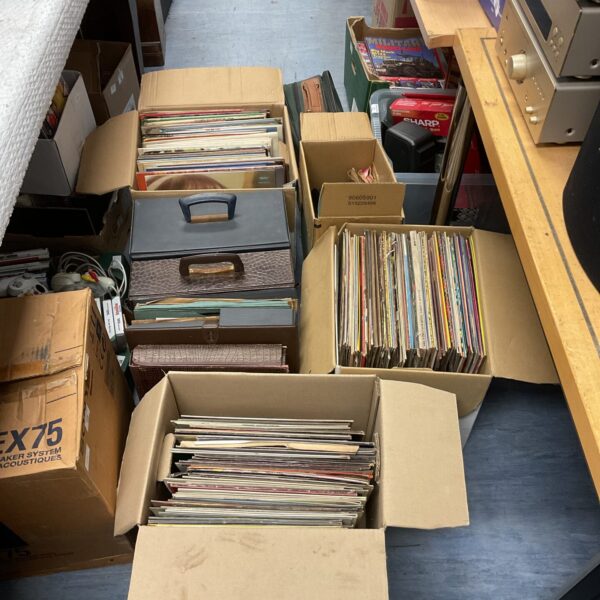Stacked boxes of vintage vinyl records for sale.