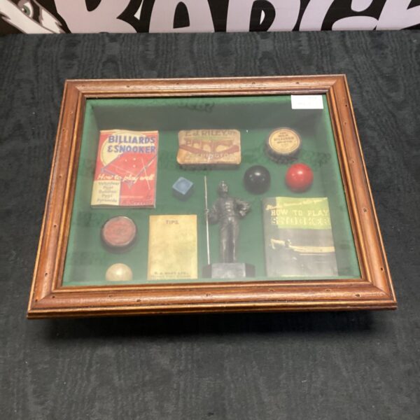 Vintage snooker diorama with miniature balls and cue.