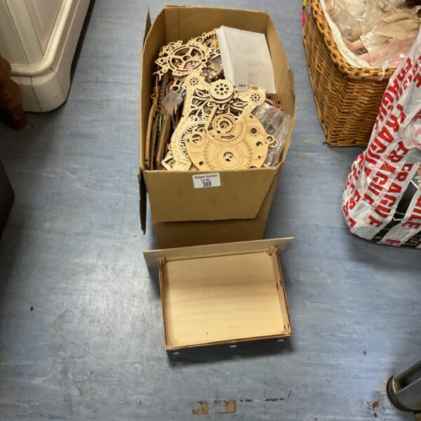 Cardboard box containing unassembled wooden model kits for crafting.
