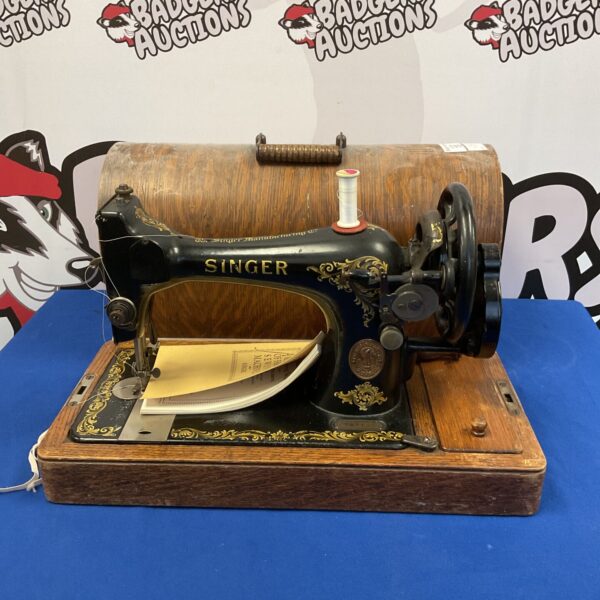 Antique Singer sewing machine with hand crank, vintage collectible.
