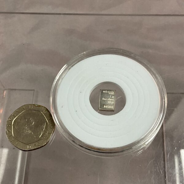 1g silver ingot displayed with a British coin for scale.