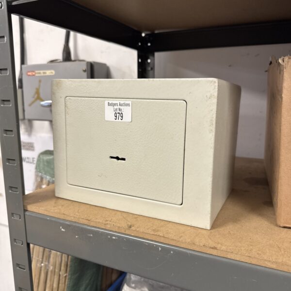 Vintage small metal safe with key lock for secure storage.