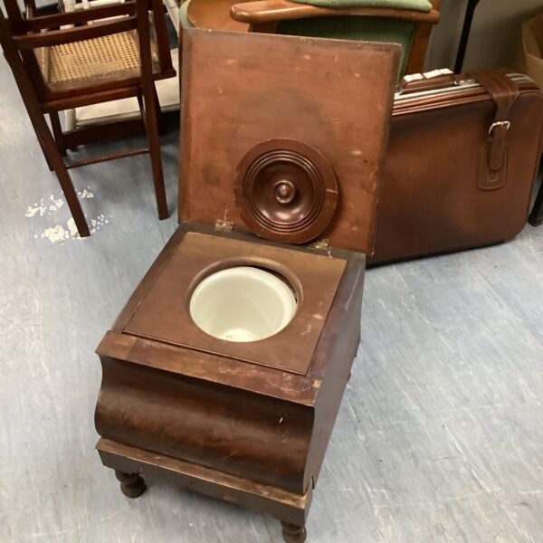 Antique portable wooden toilet with lift-up seat.