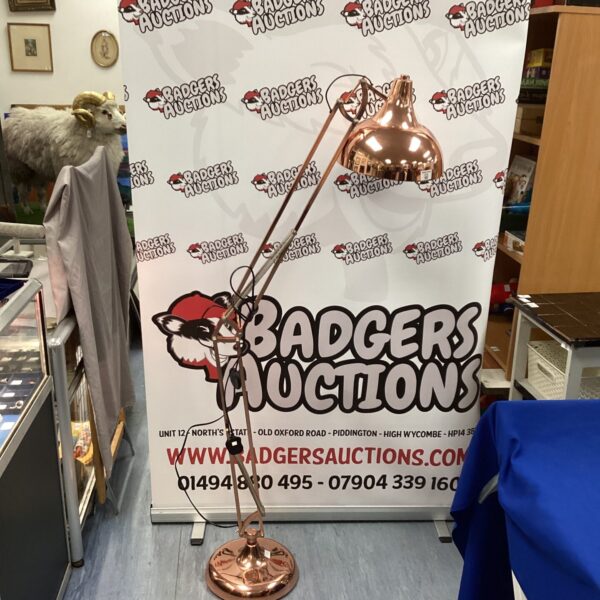 Tall copper Anglepoise style lamp in a room setting.