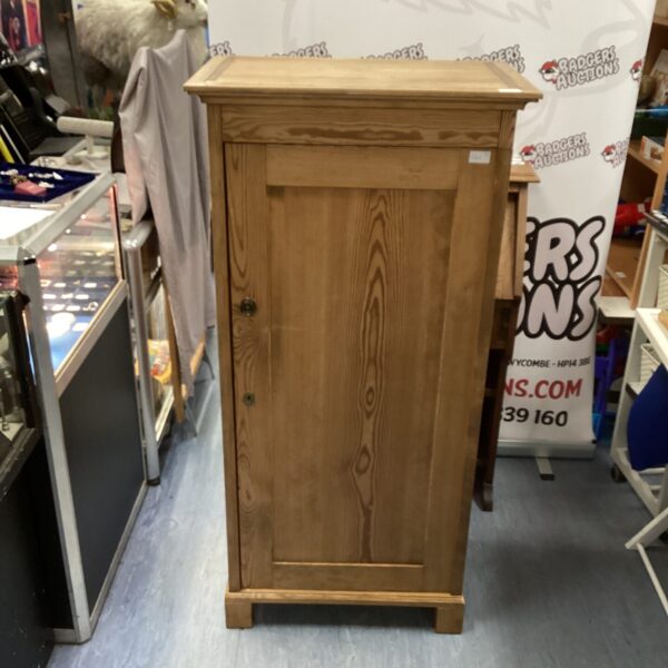 Rustic pine cabinet with a single door, ideal for storage.
