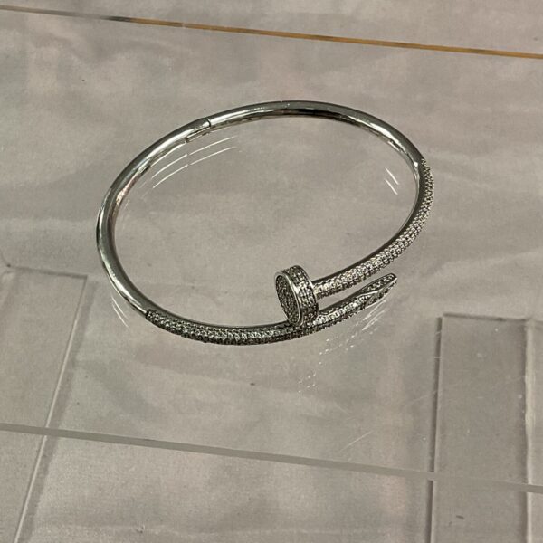 Silver-tone nail bracelet with stone encrusted detailing.