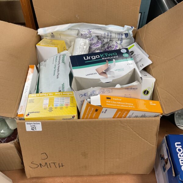 Assorted medical supplies including Urgo K2 wound dressings in a box.