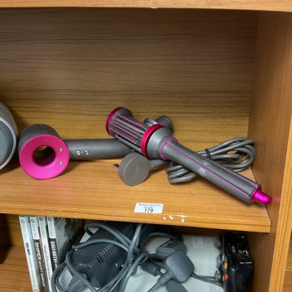 Dyson hair dryer brush styling tool for smooth hair.