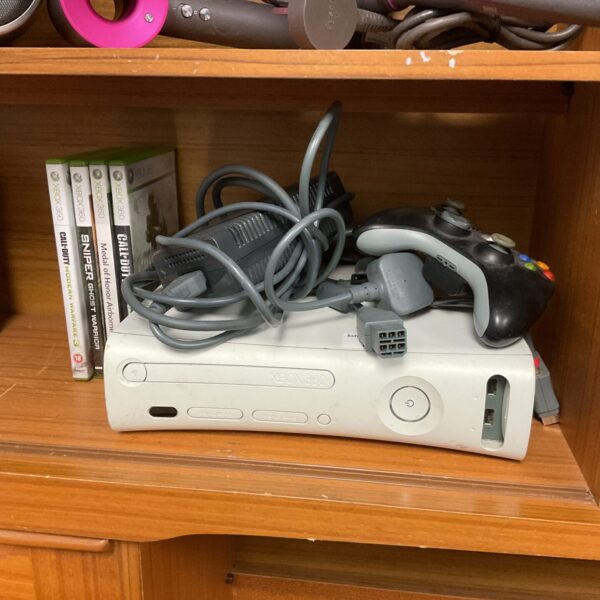 Microsoft Xbox 360 console with games and controller displayed.