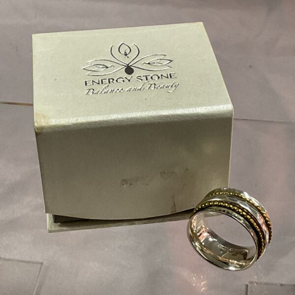 Close-up of a sterling silver spinner ring size U with energy stone.