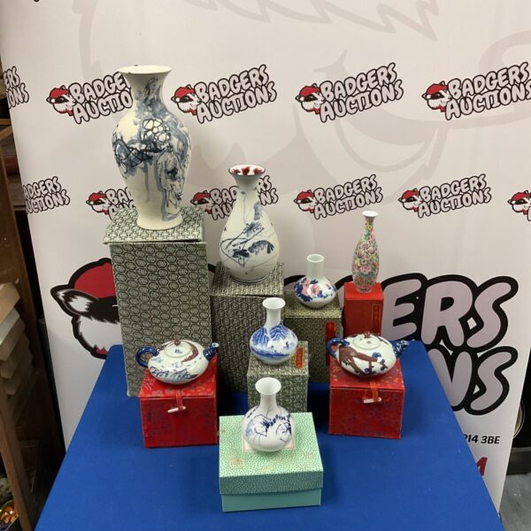 Collection of antique Chinese vases and teapots on display.