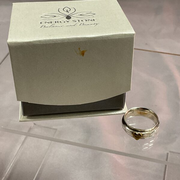 Close-up of sterling silver spinner ring with heart energy stone.