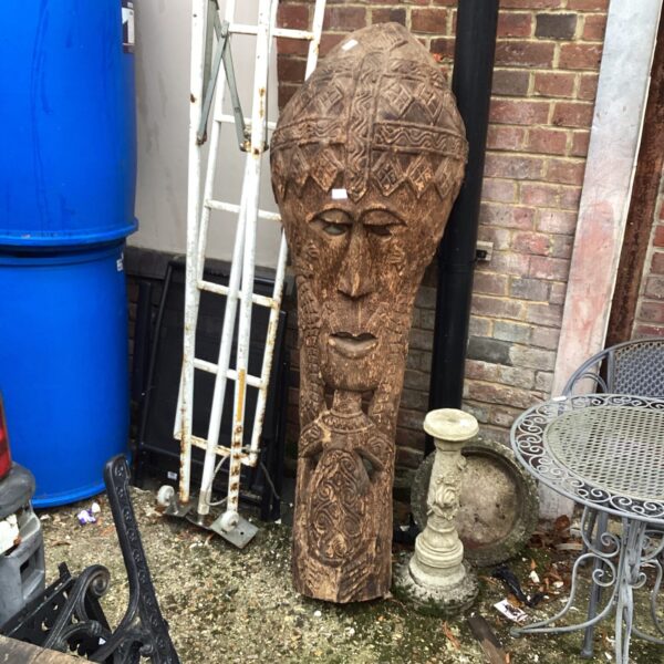 Hand-carved wooden tribal Maori face mask with intricate details.