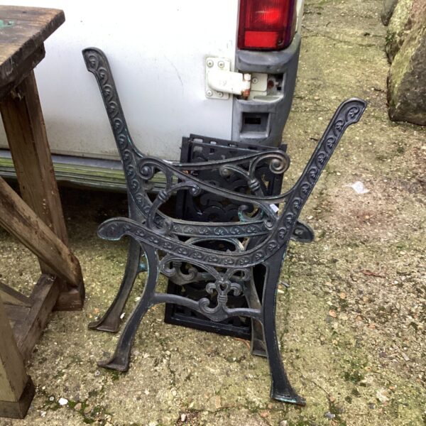 Antique wrought iron garden bench legs with scrolling details.