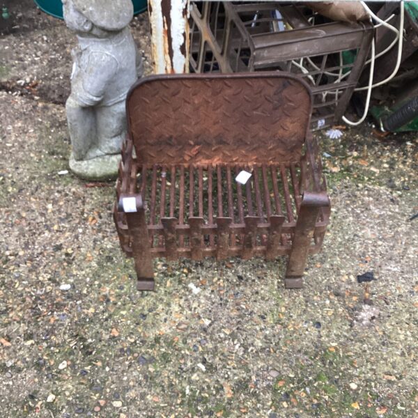 Antique wrought iron fire grate with decorative scrolling design.