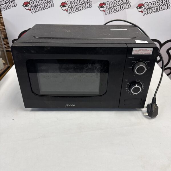 Black Abode microwave front view, used kitchen appliance.