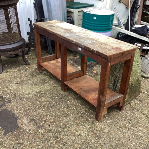 Vintage wooden workbench with shelf, ideal for workshop or garden.