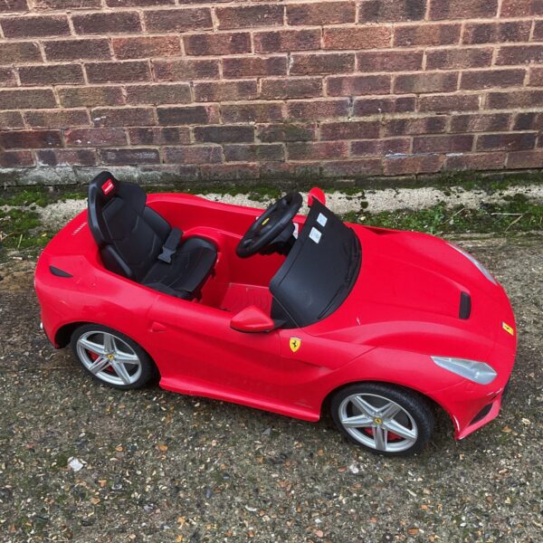 Red electric ride-on Ferrari toy car for children.