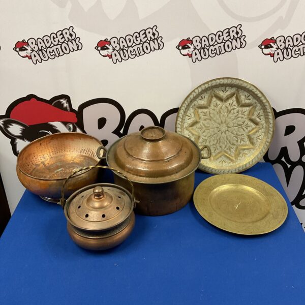 Vintage copper pot, bowl, and brass plates in a collection.
