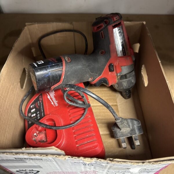 Milwaukee M12 cordless screwdriver with charger and battery.