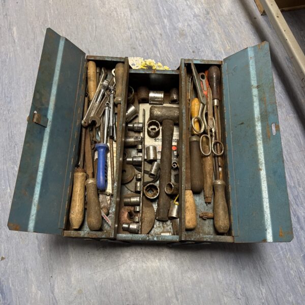 Vintage metal toolbox filled with antique hand tools.