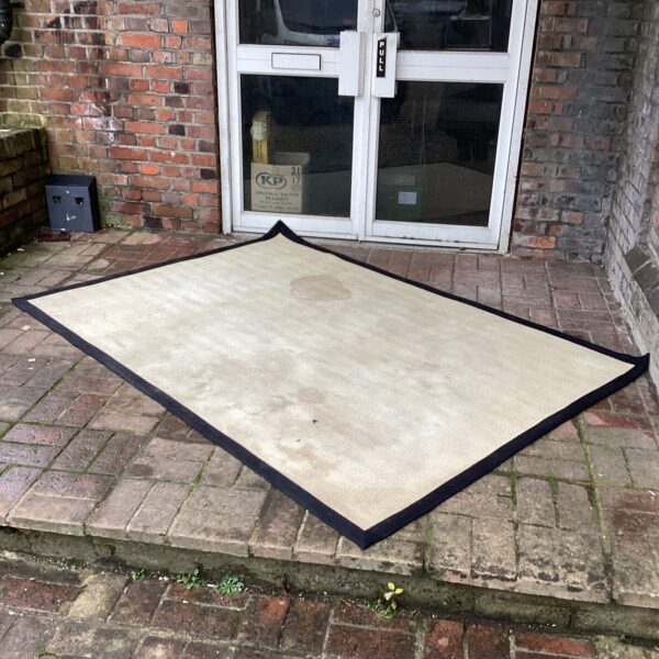 Large cream rug, approximately 7ft x 5ft, for living room decor.