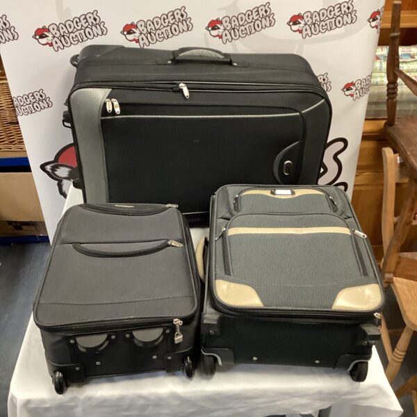 Three vintage suitcases with wheels, ideal for travel or storage.