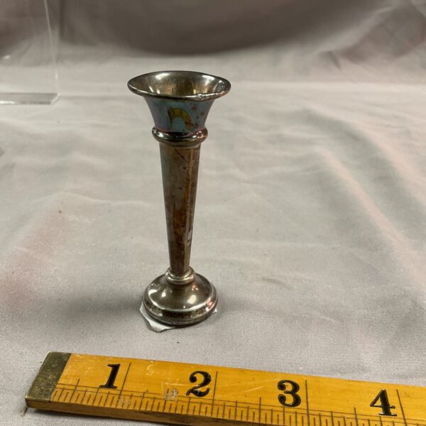 Vintage silver trumpet vase on grey surface.