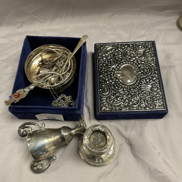 Silver scrap lot featuring a small embossed dish and decorative spoon.