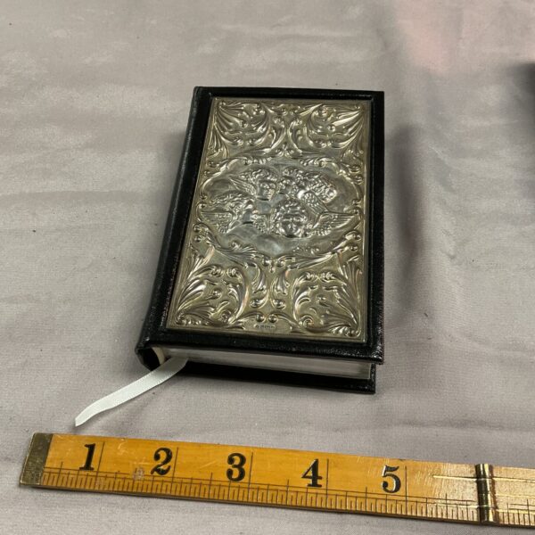 Antique silver-mounted bible with intricate floral designs on the cover.