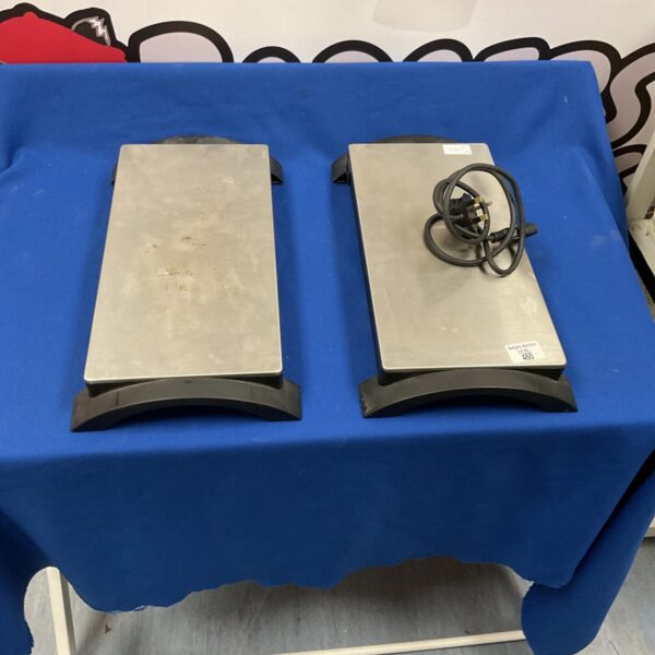 Two black vintage electric hotplates for cooking.