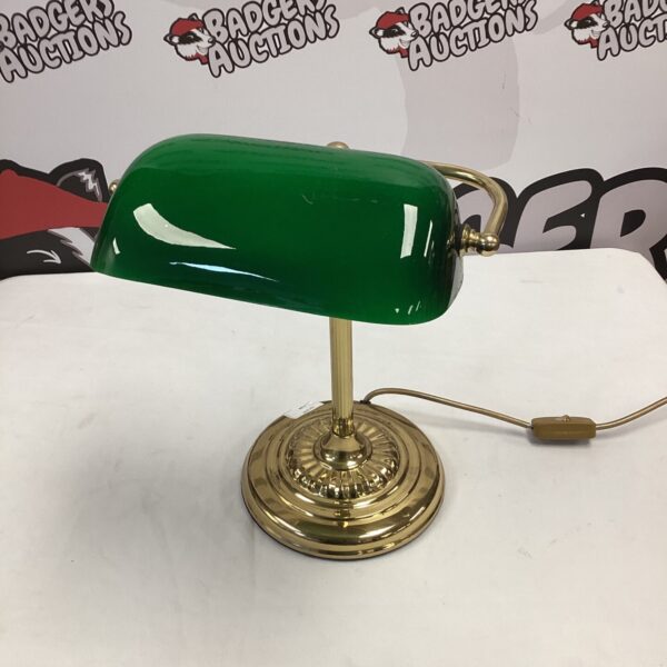 Vintage green glass banker's lamp on a desk.