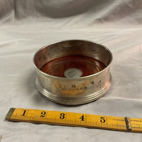 Antique sterling silver wine bottle coaster with textured surface.