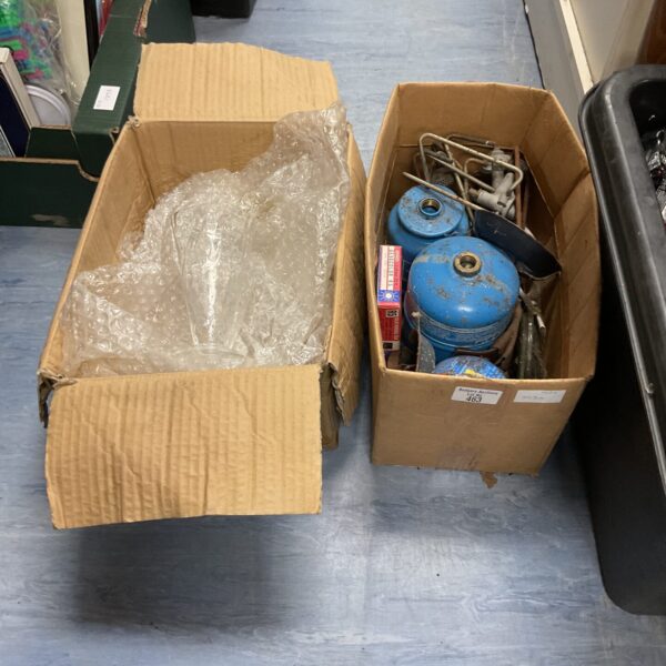 Box containing a camping heater and glassware for outdoor use.