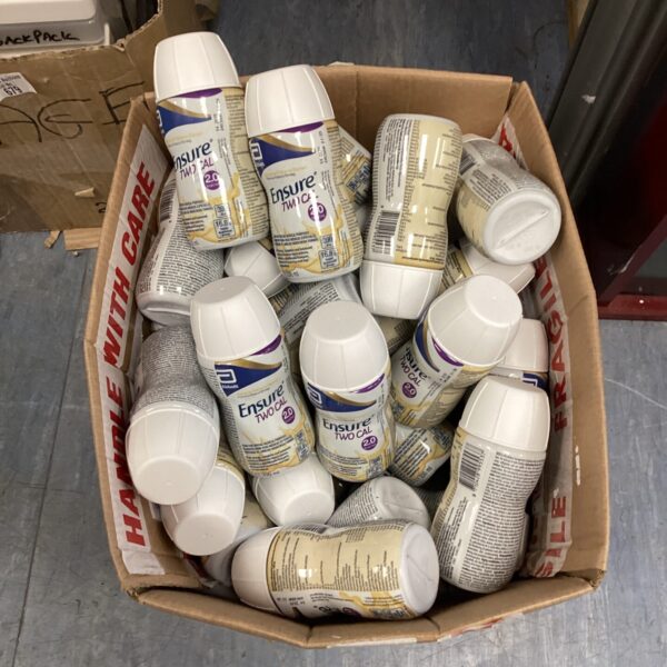 Multiple bottles of Ensure low calorie banana flavoured drinks in a cardboard box.