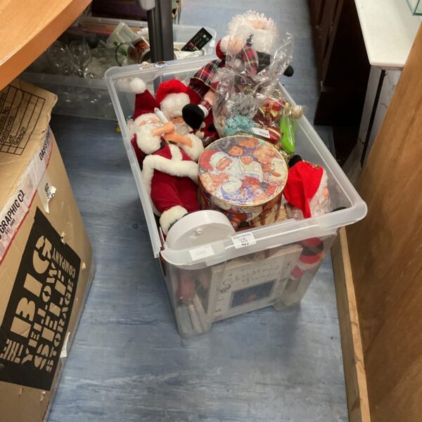 Box of Christmas decorations including Santa figurines and festive ornaments.