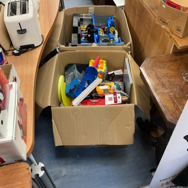 Mixed toy lot in cardboard boxes, vintage and modern playthings.