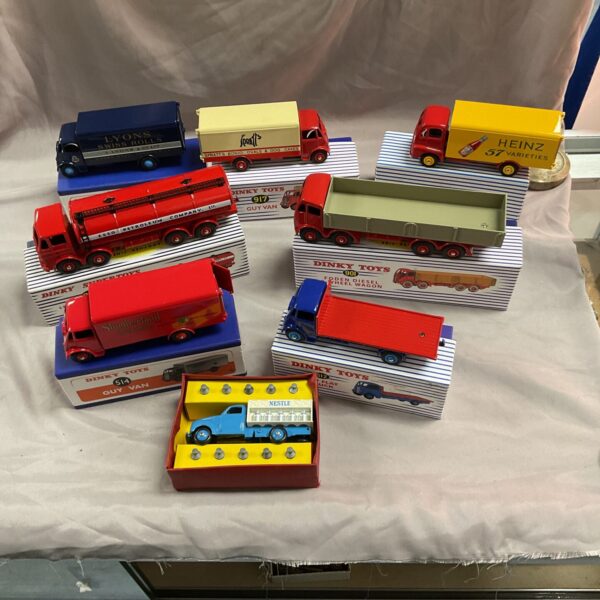 Group of vintage Dinky Toys diecast vehicles, including vans and trucks.