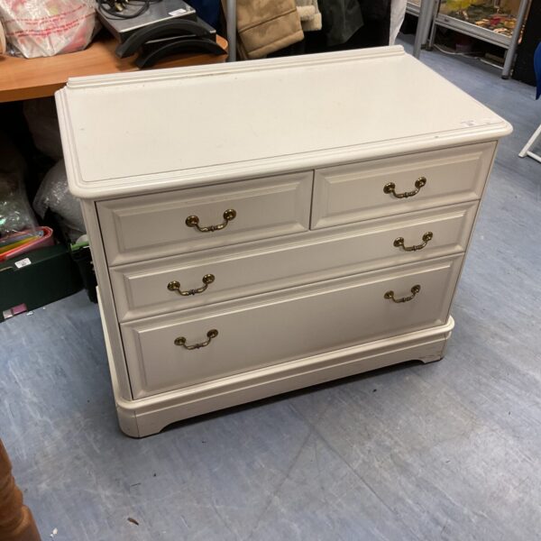 White chest of drawers with two over two configuration for bedroom storage.