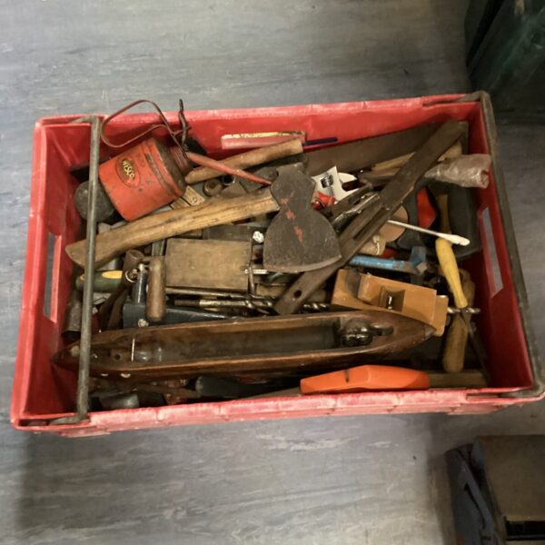 Red tray filled with a variety of vintage woodworking tools.