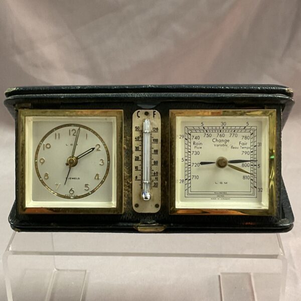 Vintage travel clock and barometer showing clock face and barometer dial.
