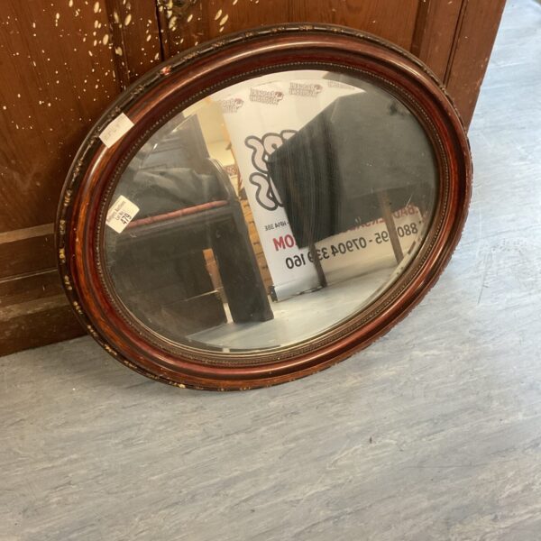 Vintage mahogany framed oval mirror for wall decoration.