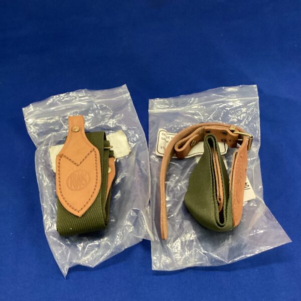 Vintage rifle slings with green webbing and leather details.