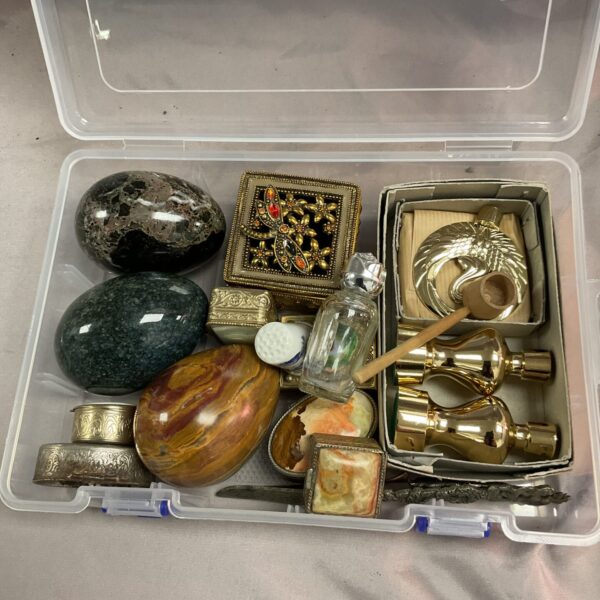 Vintage pill boxes and marble eggs in a plastic tub.