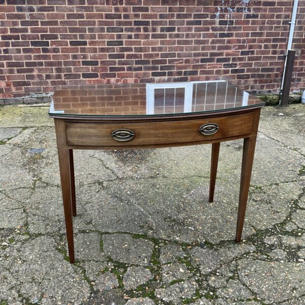 Antique mahogany side table with bow front and single drawer.