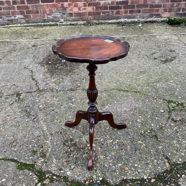 Elegant antique mahogany wine table with tripod legs.