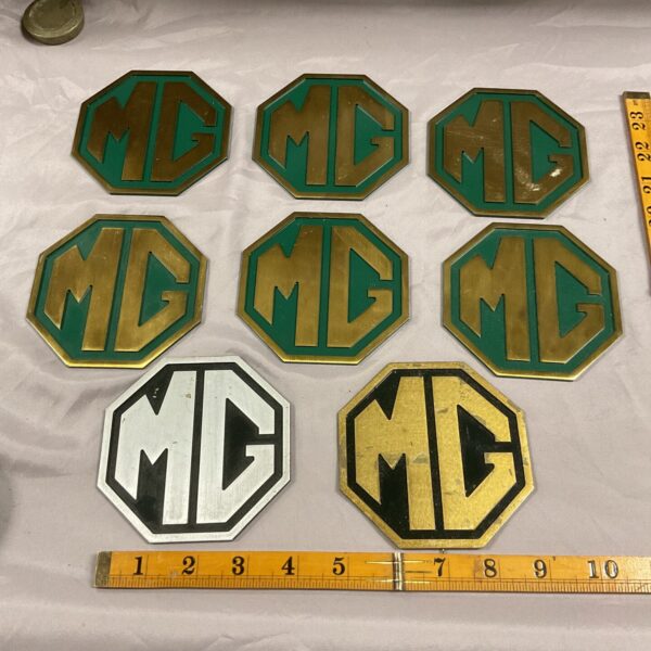 Set of six vintage MG metal plaques with logo.