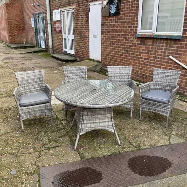 Rattan garden furniture set with round table and four chairs.